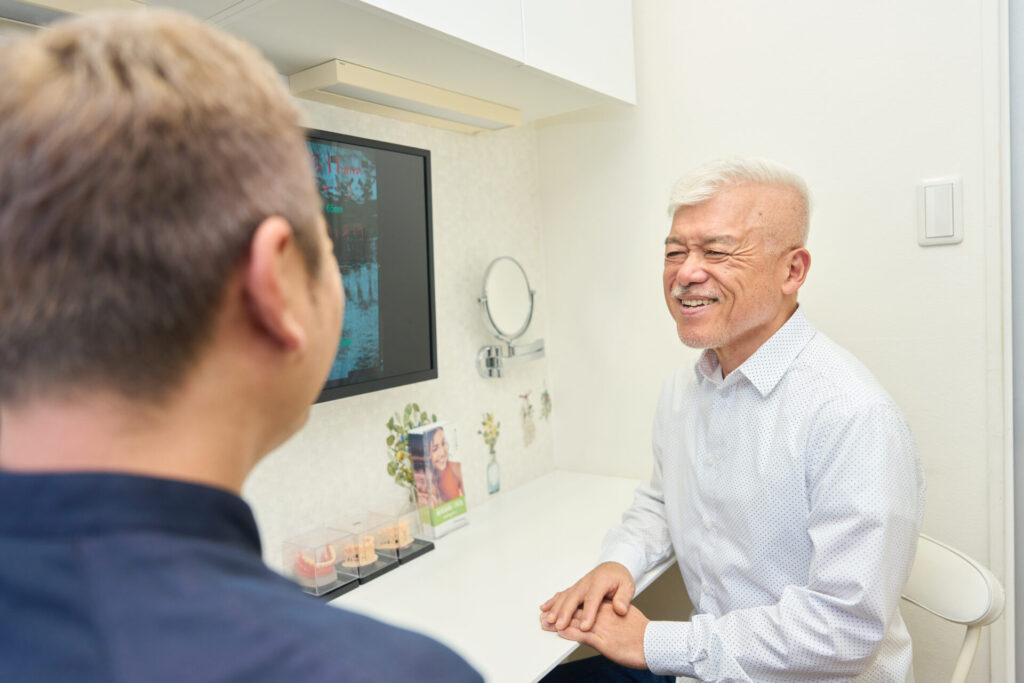 歯がボロボロの男性が治療費の相談をしている