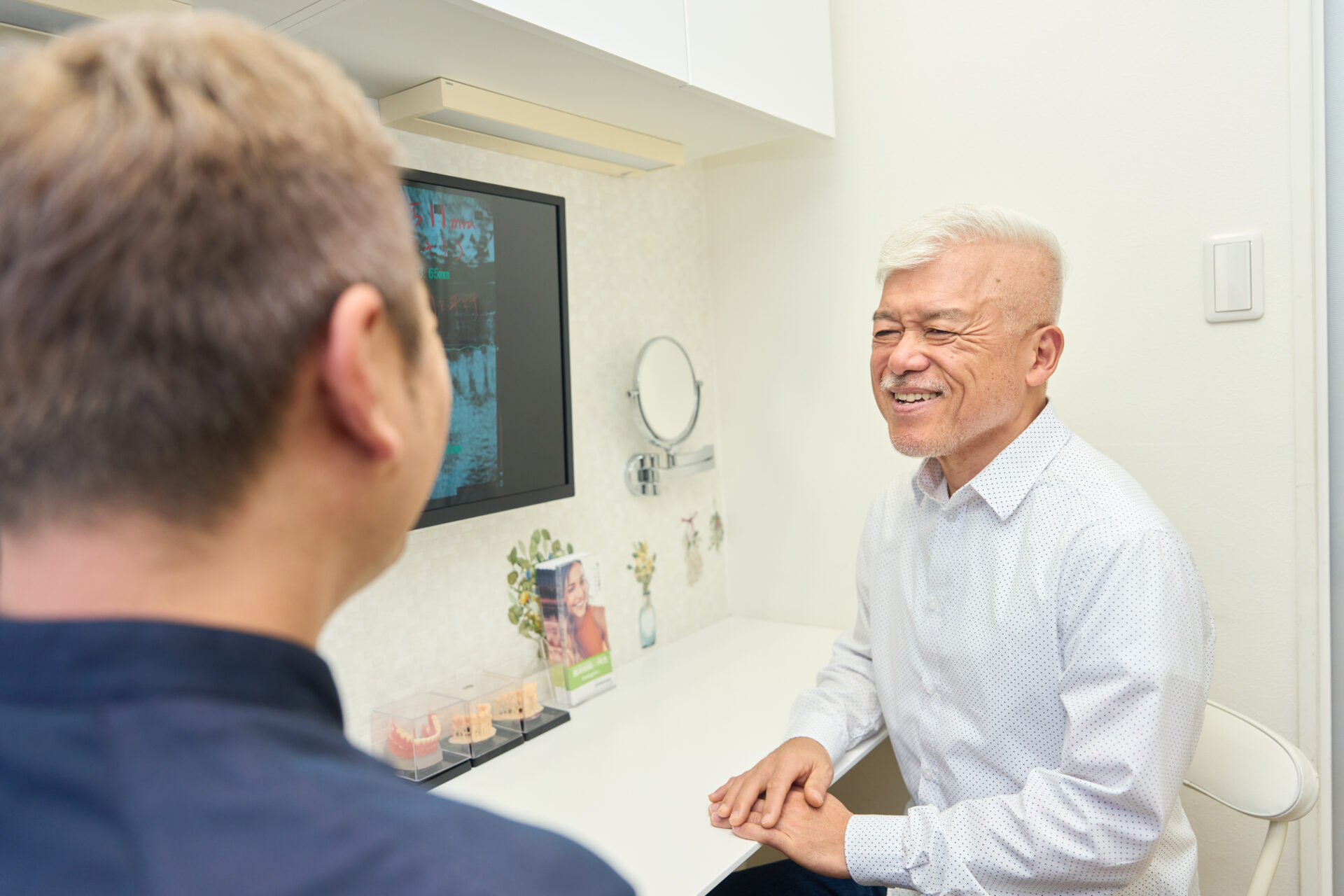 歯がボロボロの男性が治療費の相談をしている