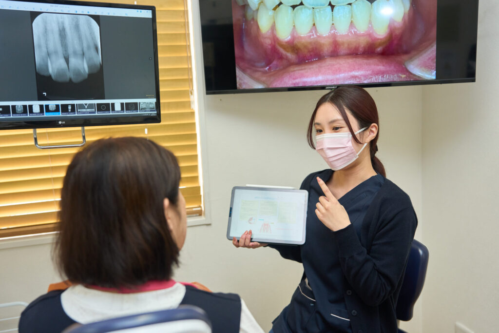 歯科衛生士が女性患者に説明をしている