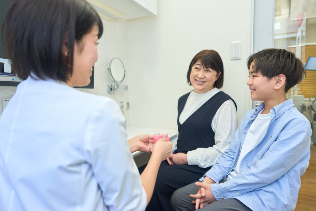 歯科医師が親子に説明を行う写真